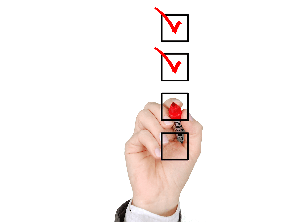 hand checking off items on to do list achieving measurable goals