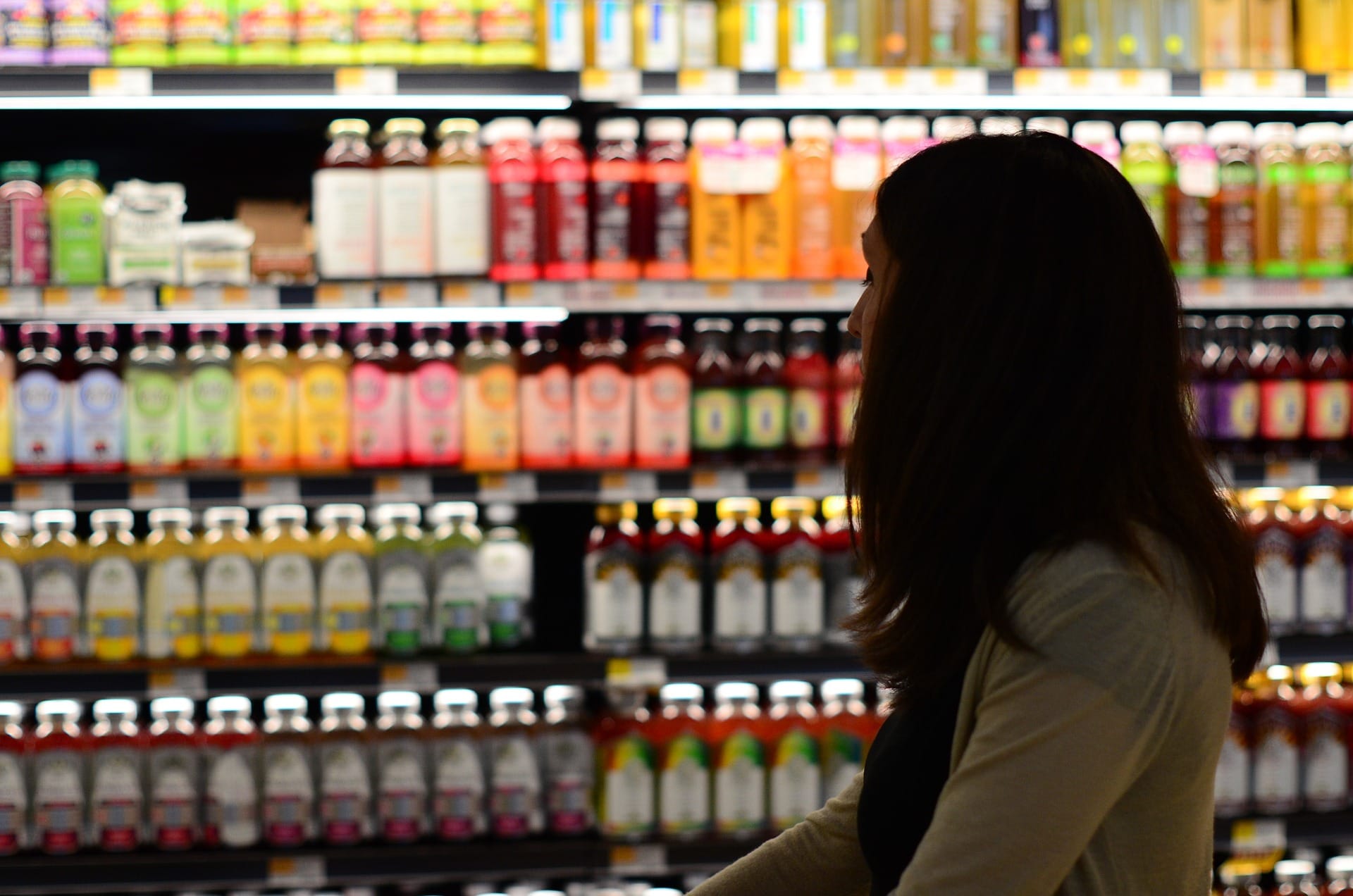 woman reading nutrition label at grocery store
