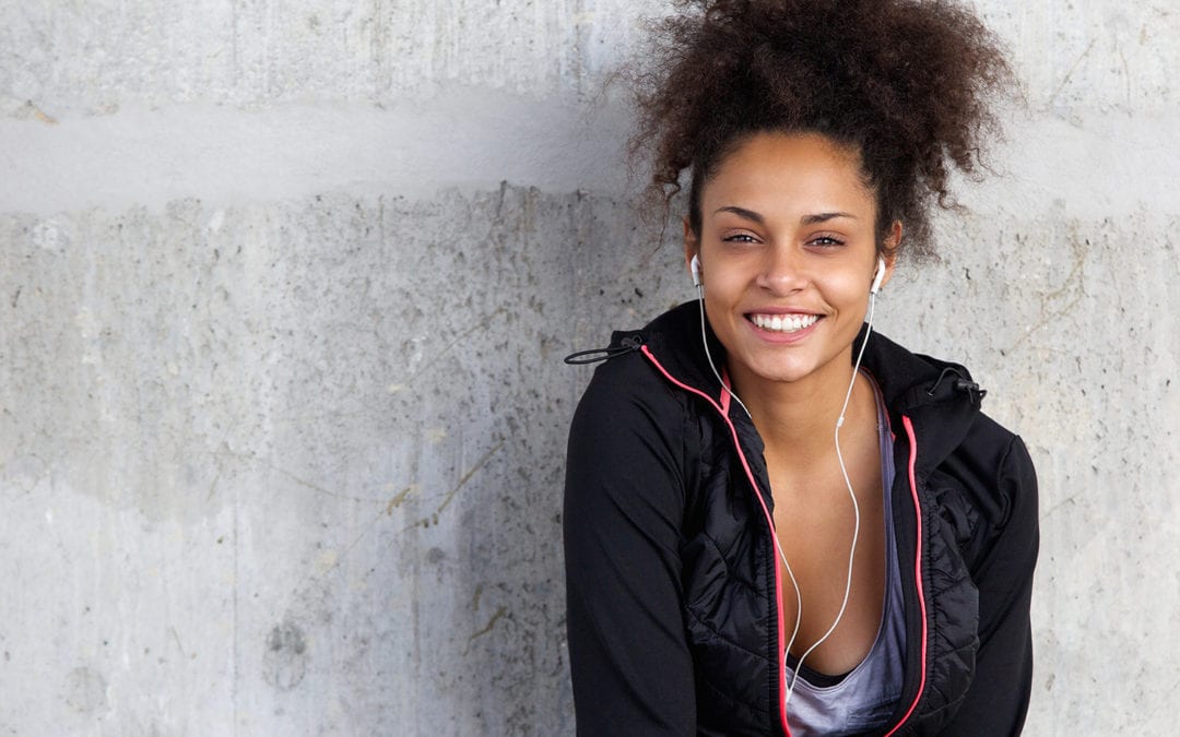 Cheerful Young Woman Listening To Music With Earphones