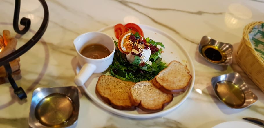Image of a plate set at a restaurant with a salad and bread