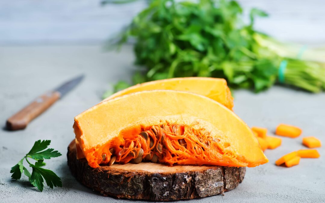 Pumpkin slice sitting on a tree trunk cutting board