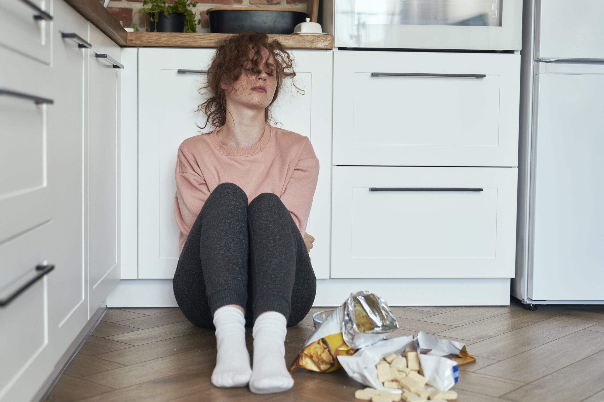 young caucasian woman eating greedily some snacks