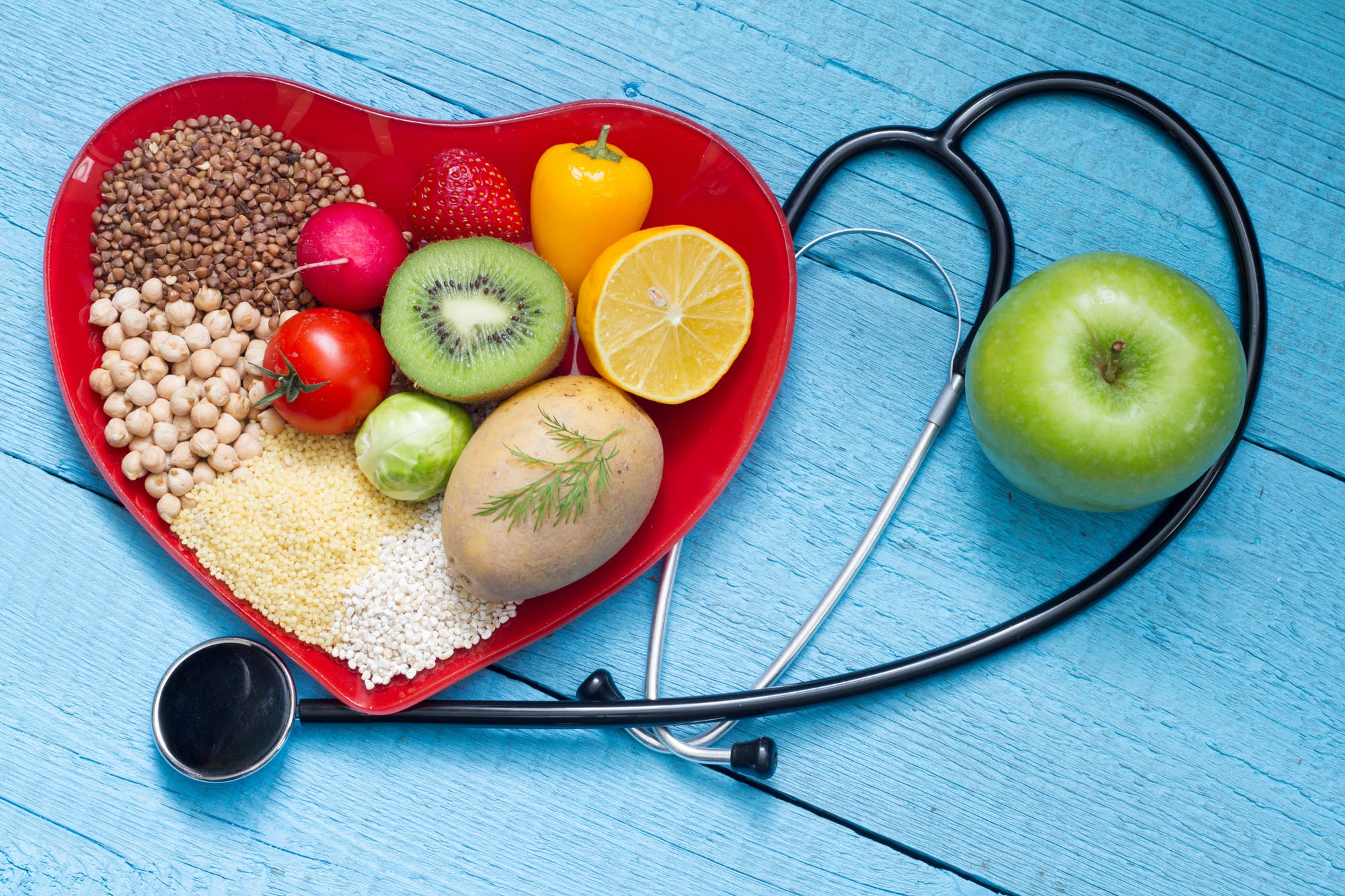 food on heart plate with stethoscope cardiology concept