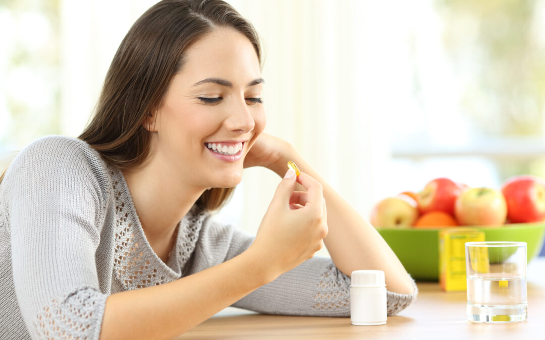 woman taking omega 3 vitamin pills