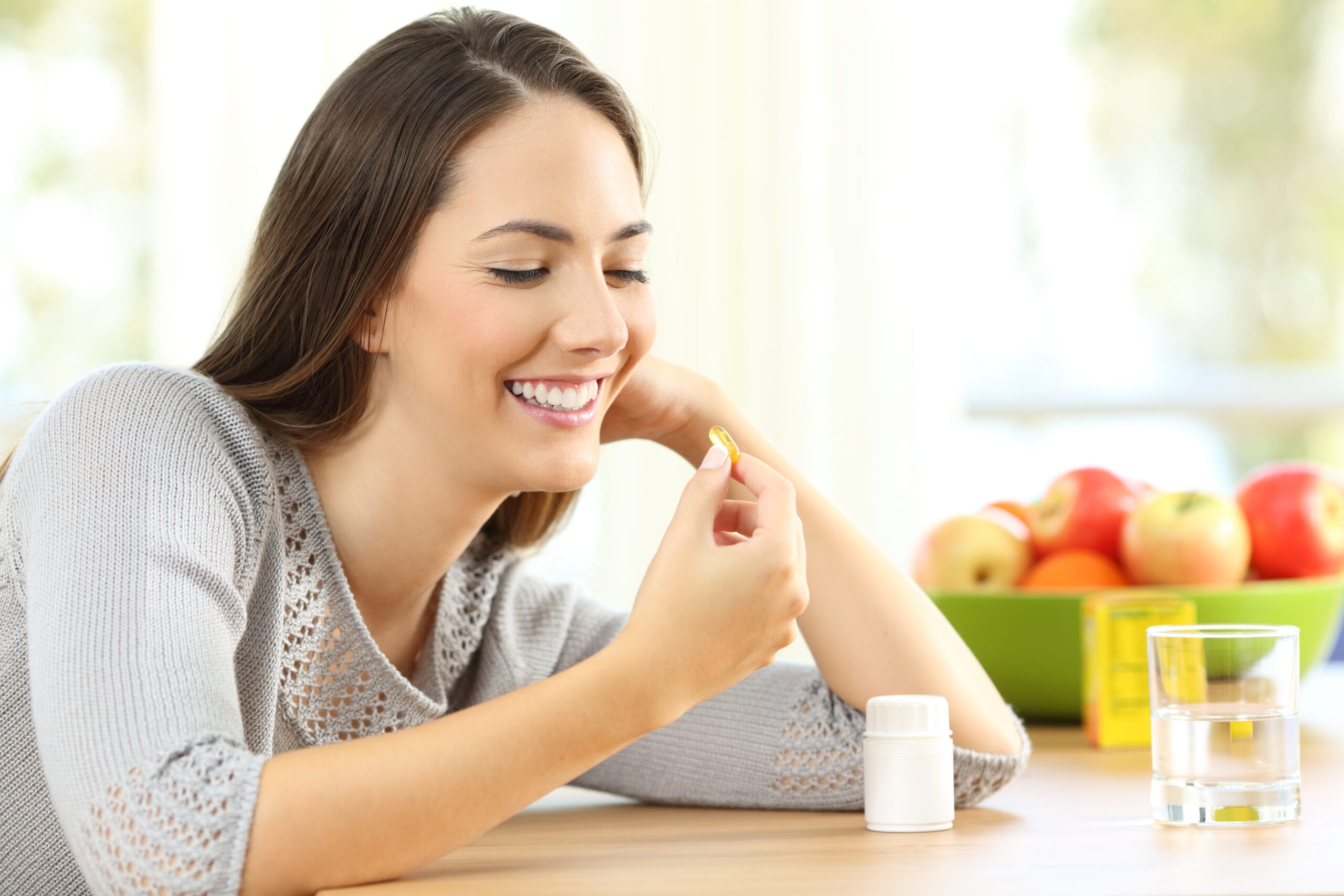woman taking omega 3 vitamin pills