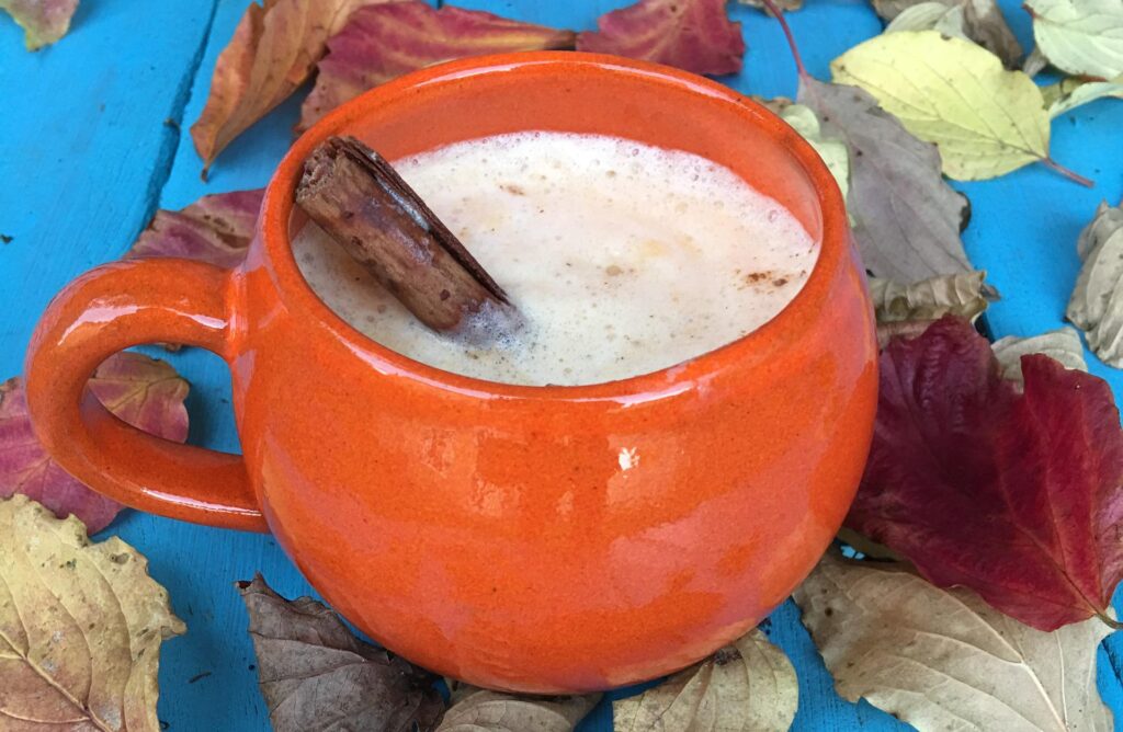 pumpkin spice latte on table with fall leaves