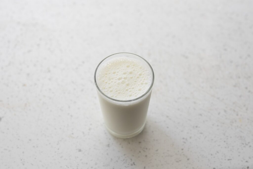 cold milk in a glass on white background
