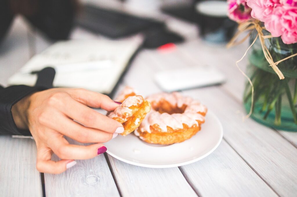 womans hand picking at donut