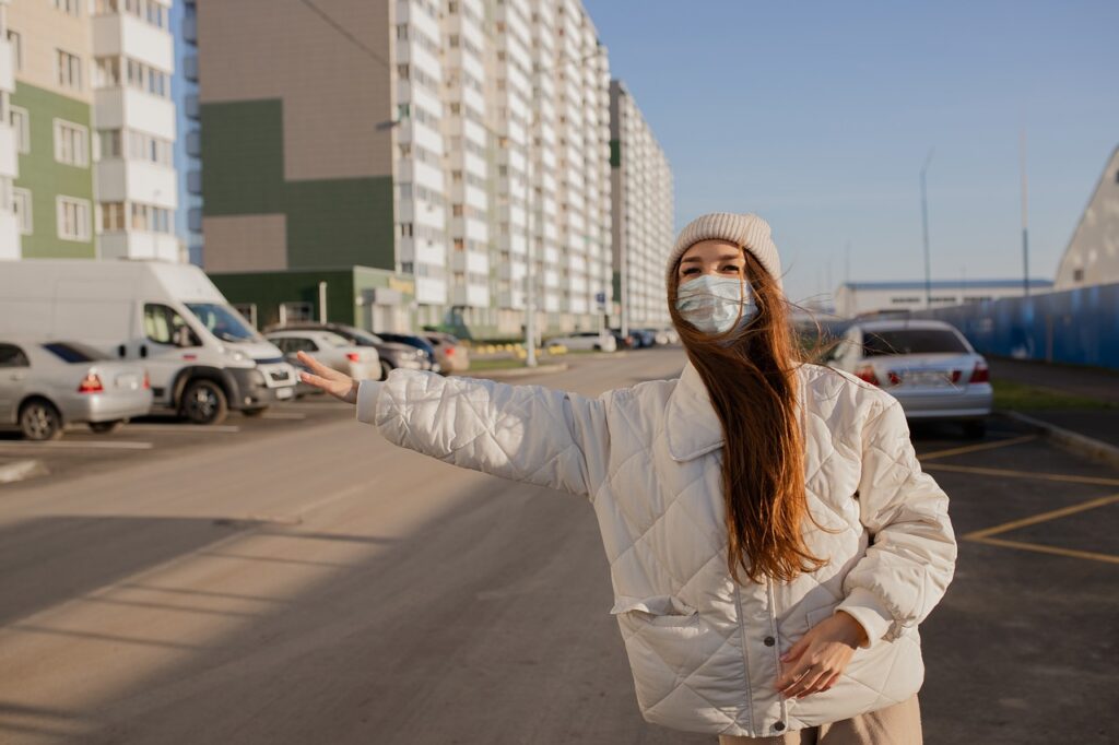 woman wearing mask to reduce covid risk getting a taxi