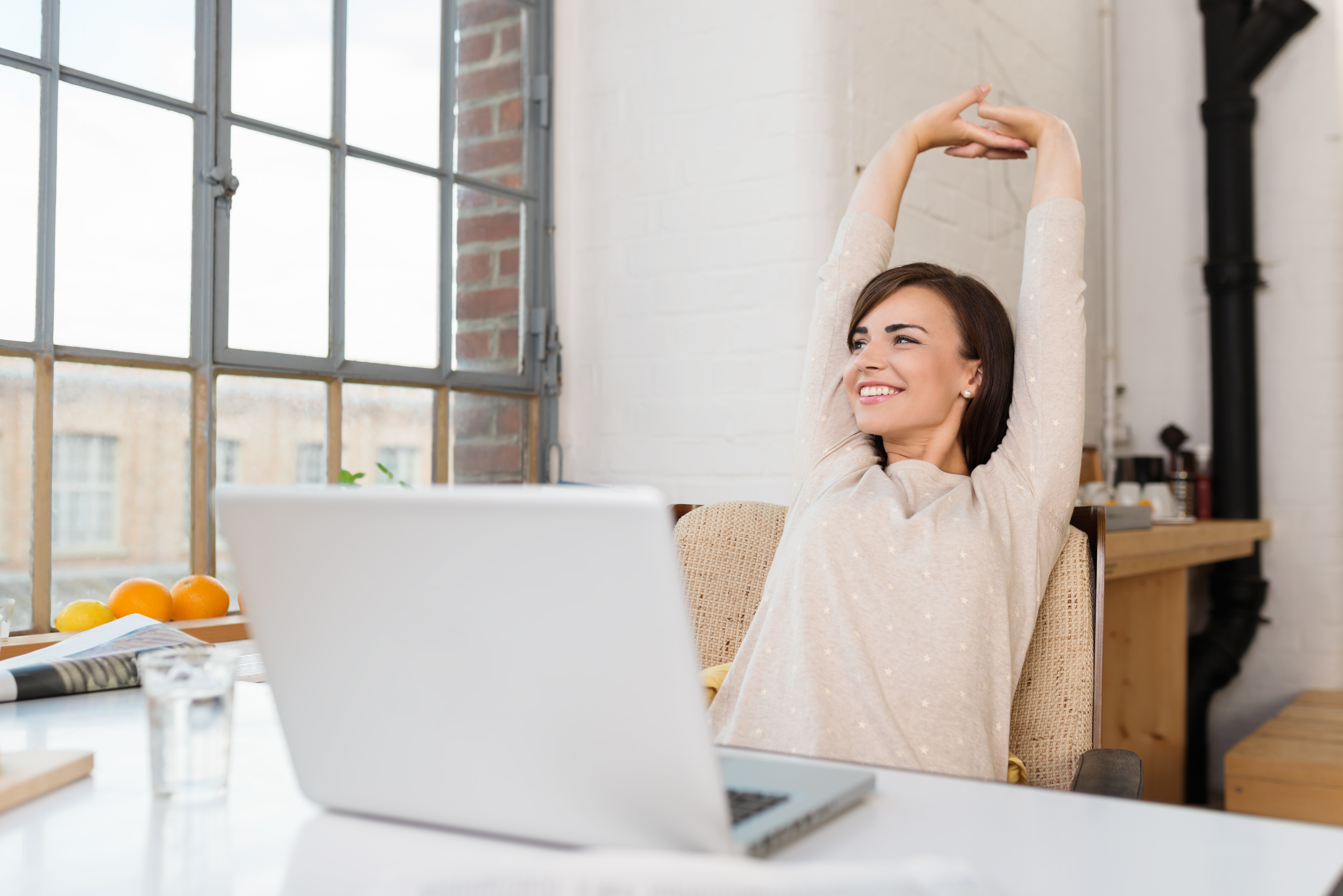 happy relaxed young woman sitting in her kitchen