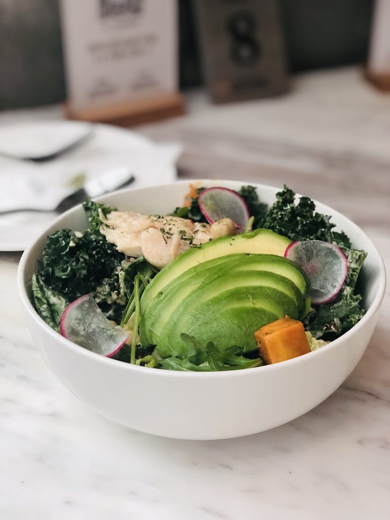 healthy_kale_salad_with_avocado_in_white_bowl