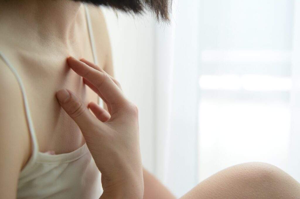 young_woman_itchy_skin_itching her chest