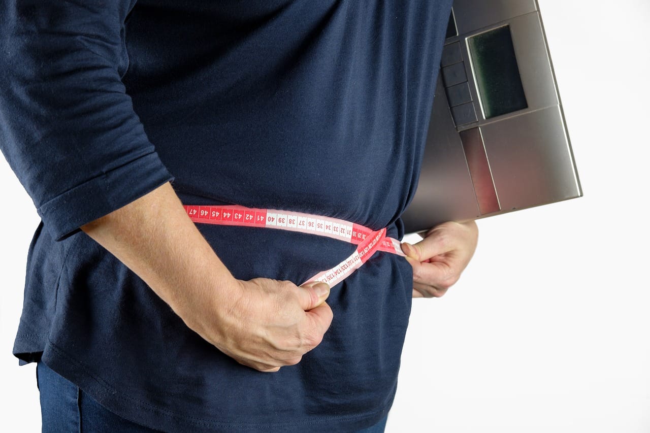 a person measuring their waist