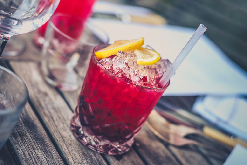 glass of red alcohol with lemon slices