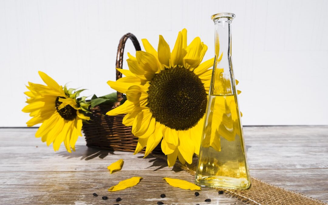 basket of sunflowers and bottle of sunflower oil on table