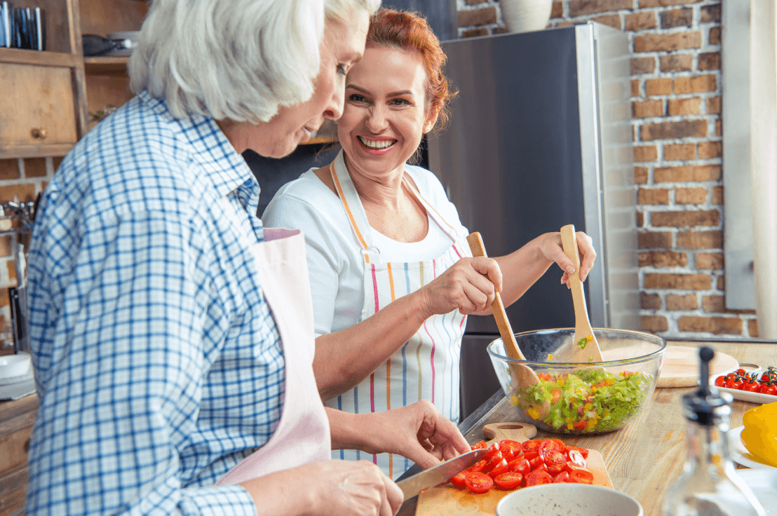 two older women making a salad in kitchen