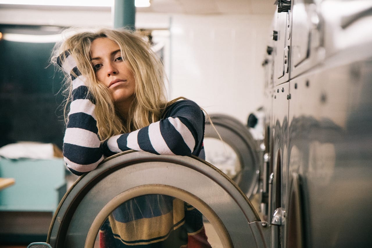 tired woman in laundromat