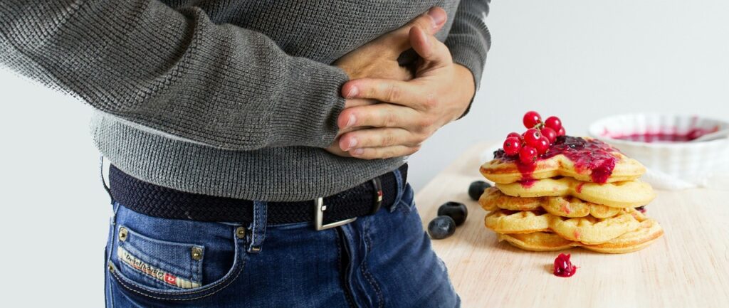 man holding his stomach like it hurts
