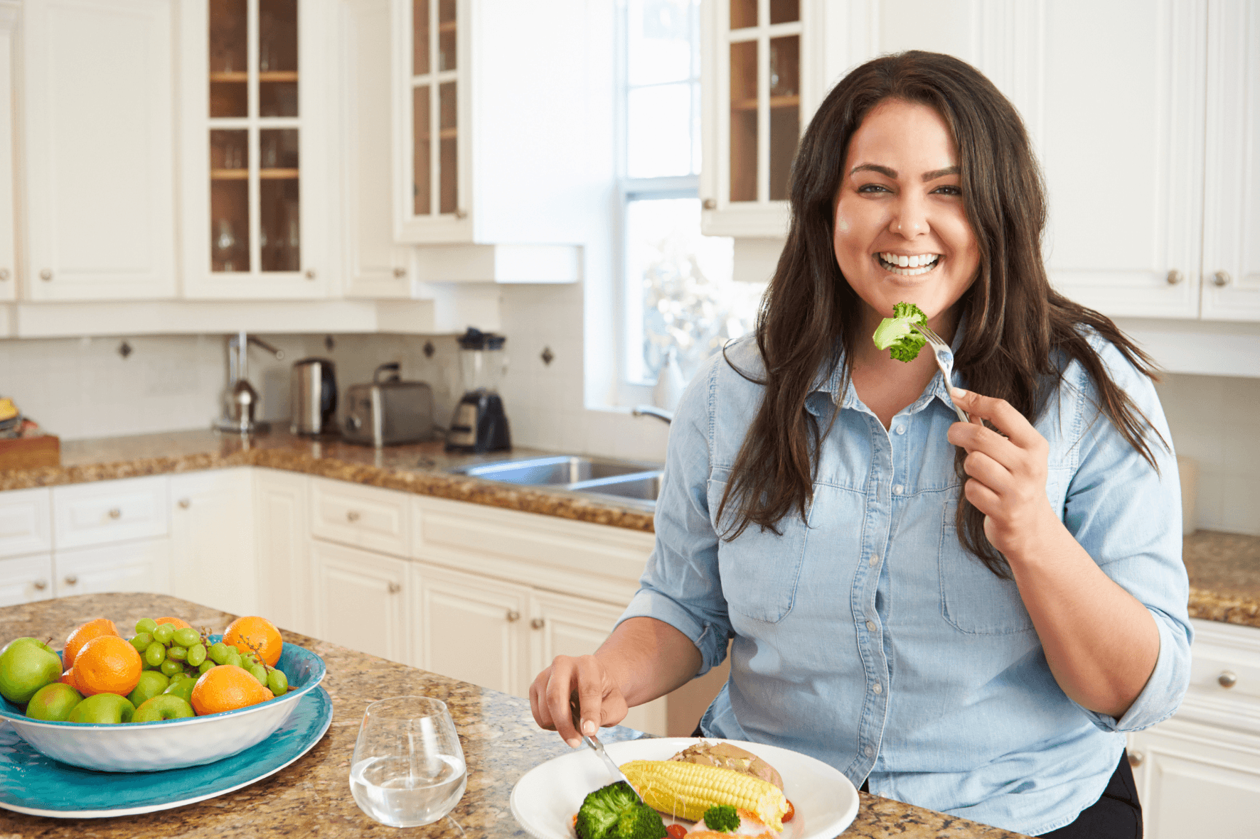 woman eating healthy portioned meal in her kitchen for weight loss
